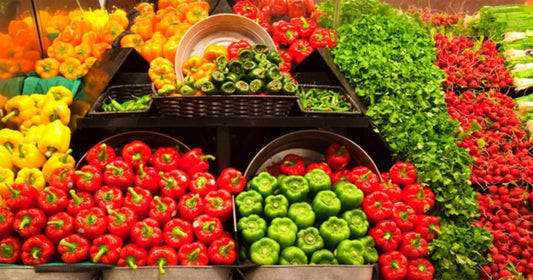 A bustling marketplace filled with colorful fruit and vegetable stalls.
