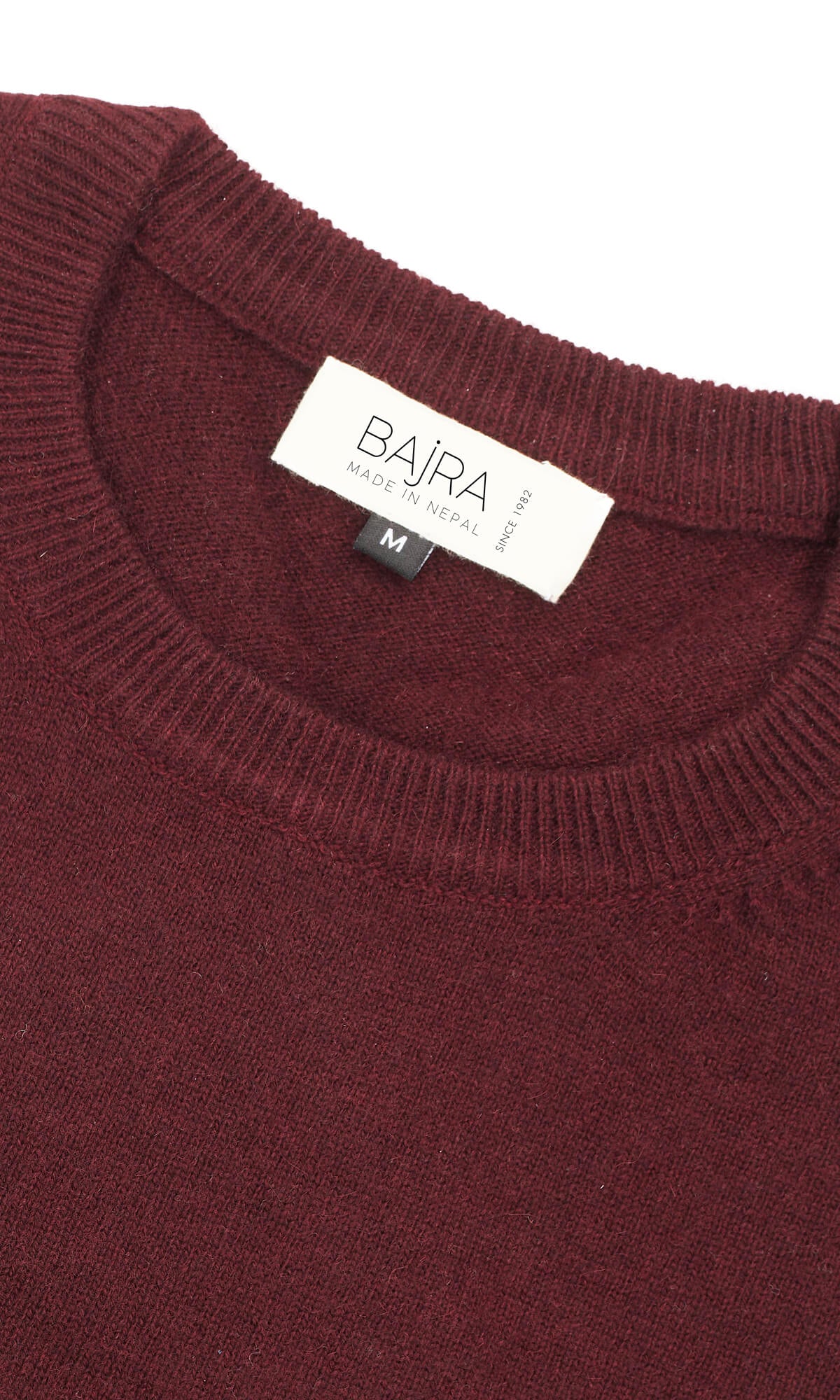 A rich Bordeaux pure cashmere cardigan in pullover style showing the close-up view of the ribbed roundneck ethically crafted in Nepal.