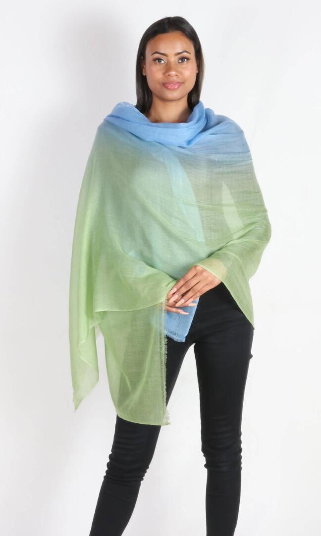 A beautiful model with a super light two-color cashmere car shawl wrapped around her body to avoid chills during her car ride.