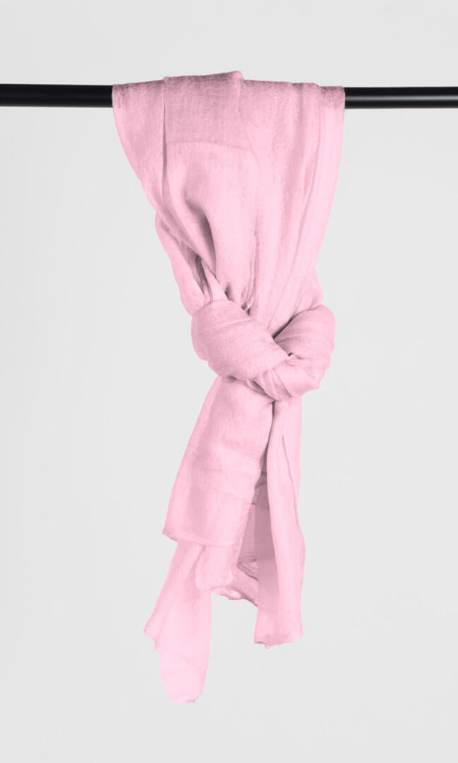 Full view of the premium handwoven 100% pure Baby Pink cashmere shawl hanging from a bar to display its loop silhouette.