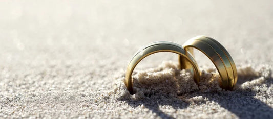 A pair of rings in the beach sand symbolizes the strength of love.
