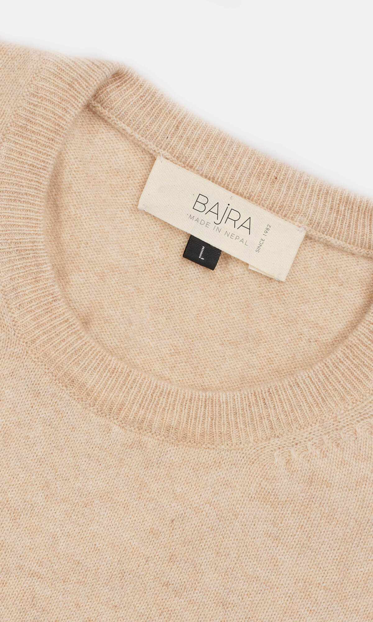 A timeless Beige cashmere cardigan in pullover style showing the close-up view of the ribbed roundneck ethically crafted in Nepal.