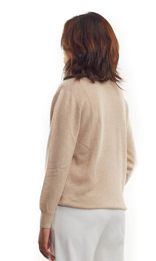 Woman wearing the timeless Beige cashmere cardigan in pullover style with roundneck and long sleeves ethically made in Nepal using sustainably sourced pure cashmere; a full back view.