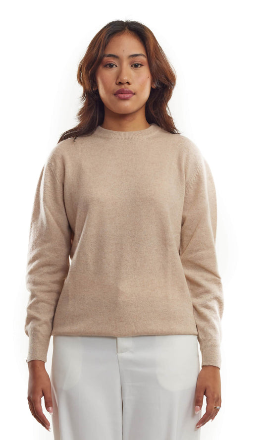Woman wearing the timeless Beige cashmere cardigan in pullover style with roundneck and long sleeves ethically made in Nepal using sustainably sourced pure cashmere; a full front view.