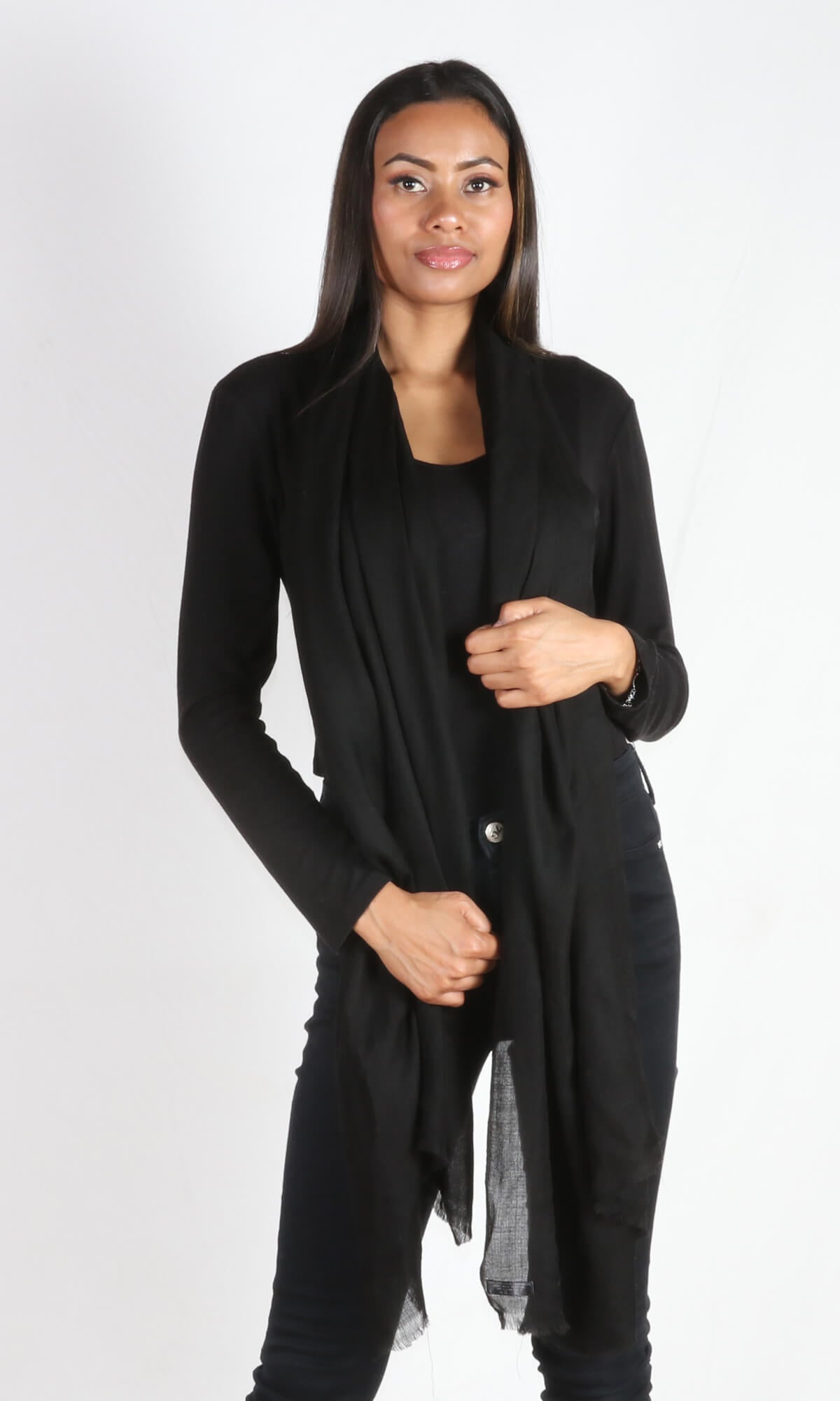 A beautiful 5ft 8 inches tall female model displays a 100% pure handmade black cashmere shawl draped around her neck to convey the message that the shawl has ample length to reach below the knees.