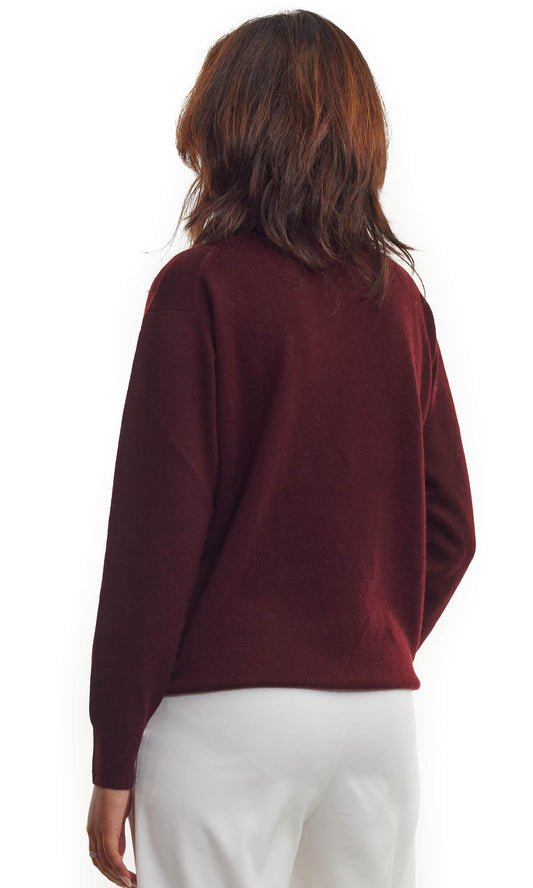 Woman wearing the rich Bordeaux pure cashmere cardigan in pullover style with roundneck and long sleeves ethically made in Nepal; a full back view.