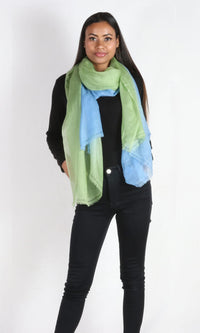 A beautiful model with a super light two-color cashmere car shawl wrapped around her neck.