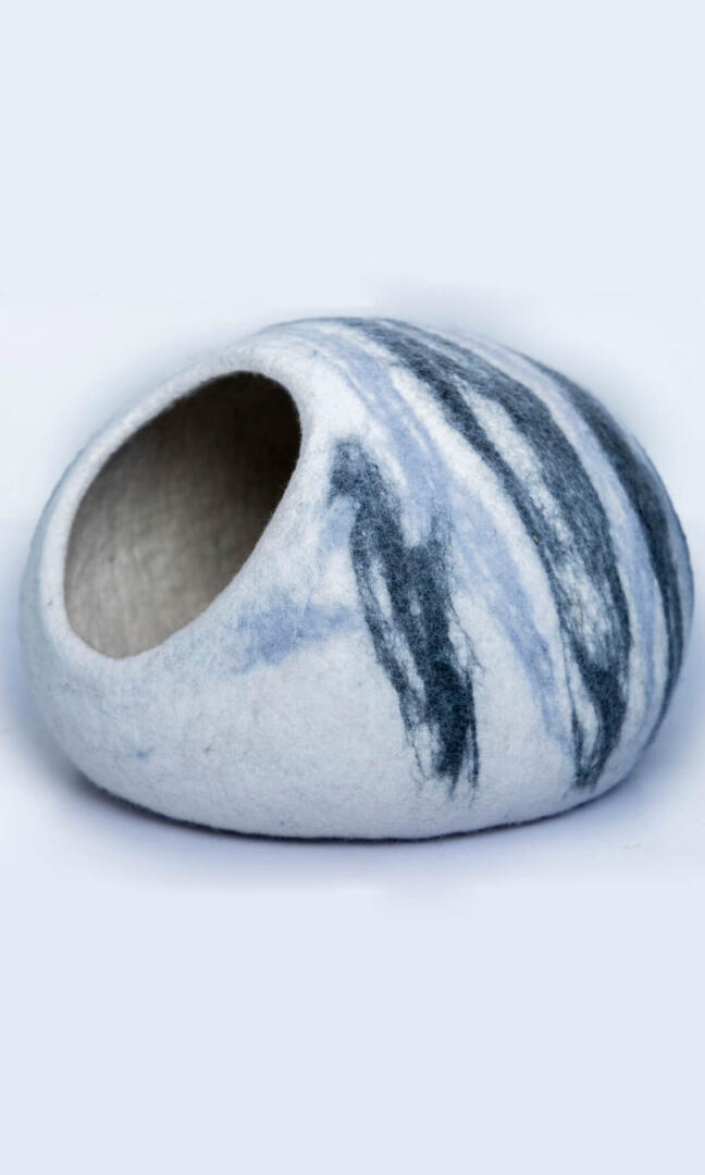 Handmade in an oval shape, the cosmic brushstroke cat cave retreat's left view features a stunning abstract design that resembles the random up-and-down stroke of a paintbrush.