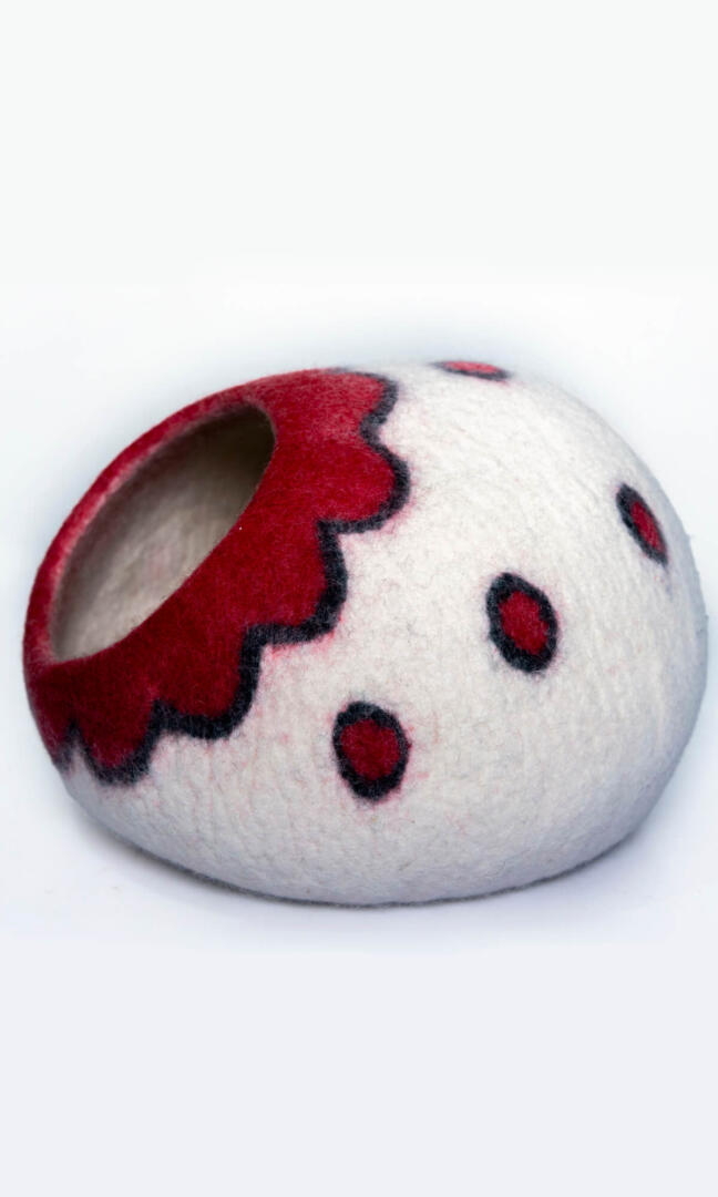 A felted wool cat cave with a Scarlet Blossom flower design entrance, and a full left-side view.