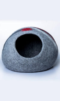 Image of Glamorous Zebra Cat Hideout, an oval-shaped cat cave with a unique and stylish design featuring a grey and black color scheme with two zebra-style white stripes and a red stripe. Handmade with premium felted wool for durability, comfort, and insulation for cats of all sizes. Perfect for providing a cozy and private space for your feline friend to rest and play. A full front entrance view.