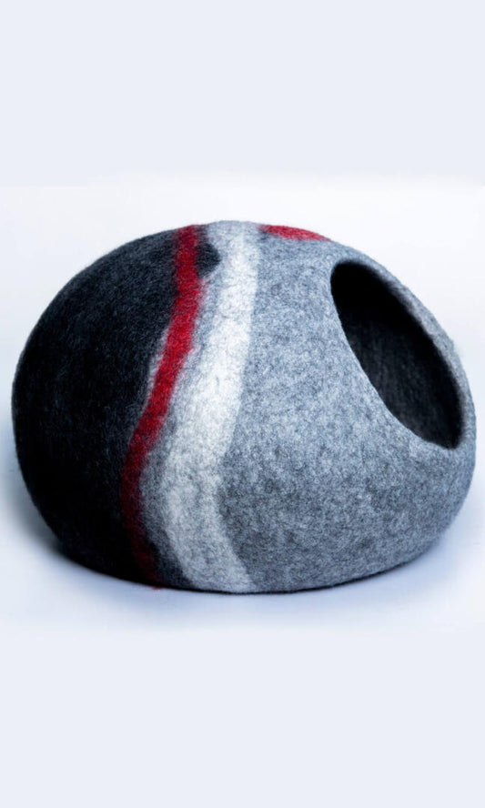 Image of Glamorous Zebra Cat Hideout, an oval-shaped cat cave with a unique and stylish design featuring a grey and black color scheme with two zebra-style white stripes and a red stripe. Handmade with premium felted wool for durability, comfort, and insulation for cats of all sizes. Perfect for providing a cozy and private space for your feline friend to rest and play. A full right-side view.