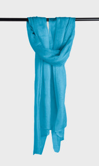 Full view of the premium handwoven 100% pure Celeste Blue cashmere shawl hanging from a bar to display its silhouette.