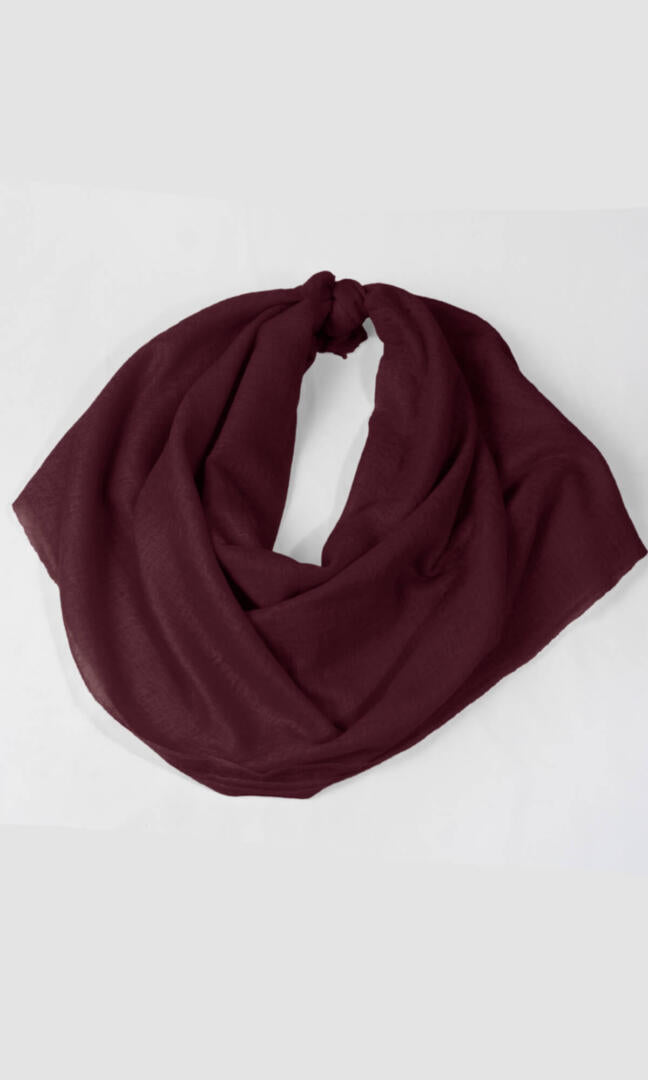 A detailed shot of the premium handwoven 100% pure Dark Burgundy cashmere shawl in a knot loop shape.