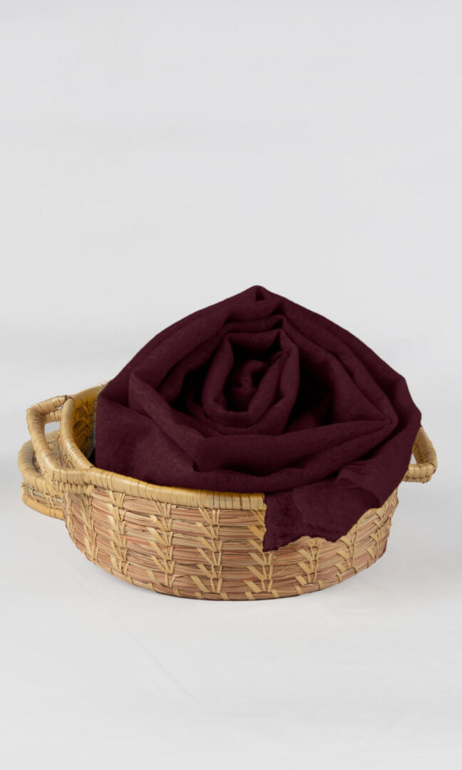 Detailed shot of the premium handwoven 100% pure Dark Burgundy cashmere shawl - placed neatly in a bamboo gift box.