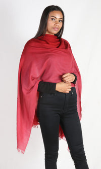 A female model displays a handmade two-tone red cashmere shawl wrapped around her body as a body wrap.